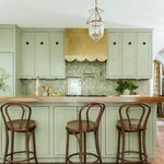 green kitchen cabinets and brass range hood