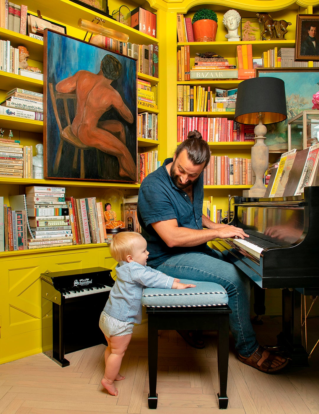 father playing piano with son in yellow room