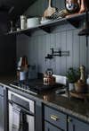 black kitchen with grey granite countertops