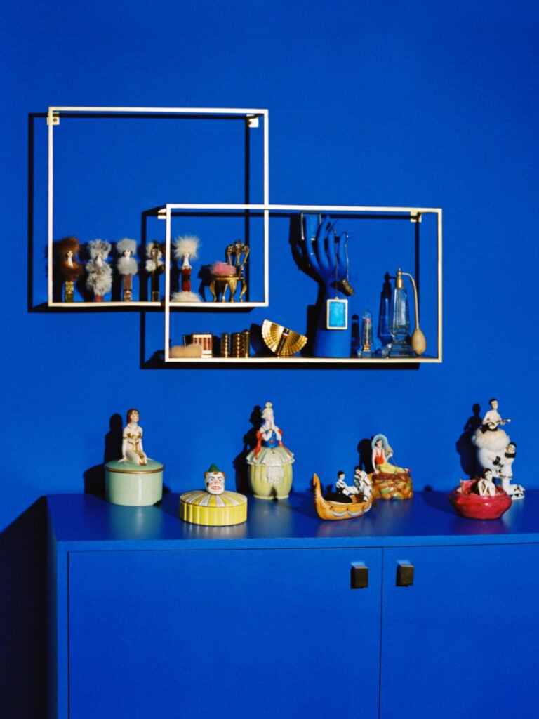 blue wall with brass shelves