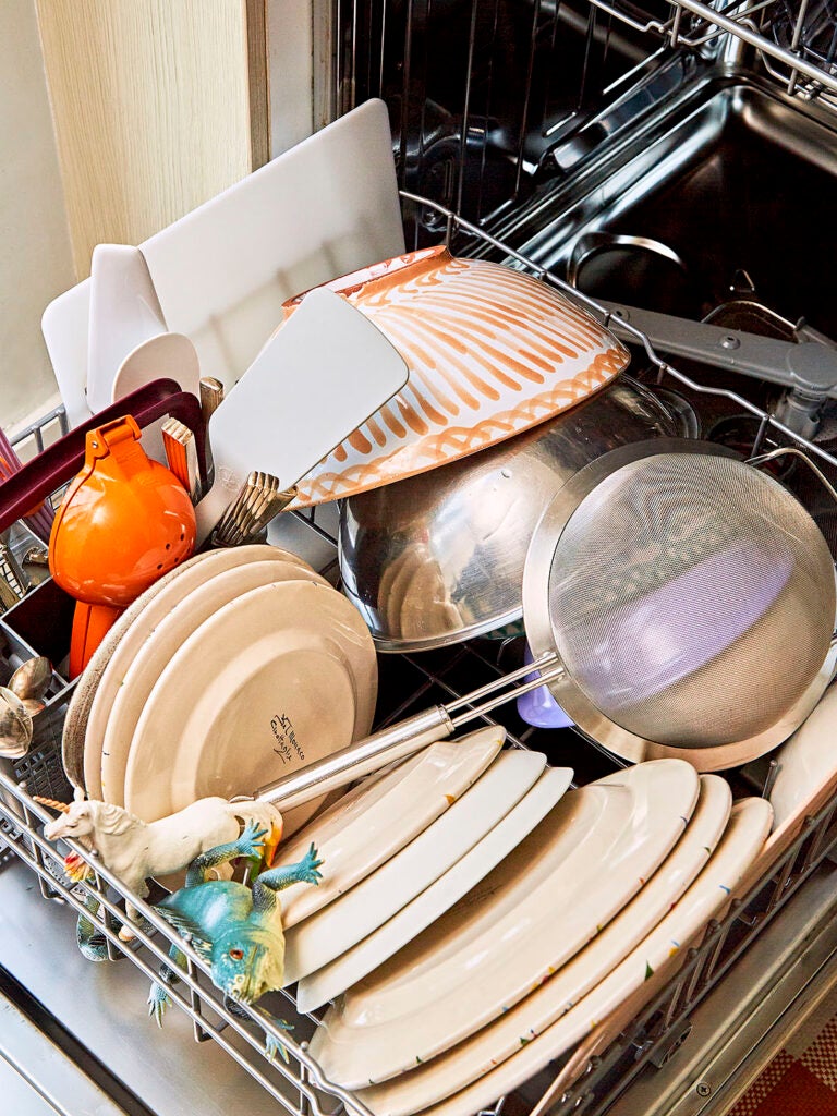 dishes, utensils, and dinosaur toys in dishwasher
