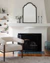 white tapered fireplace with boucle armchair