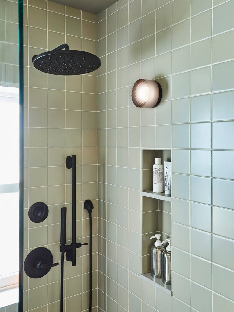 green tiled walk-in shower with black fixtures