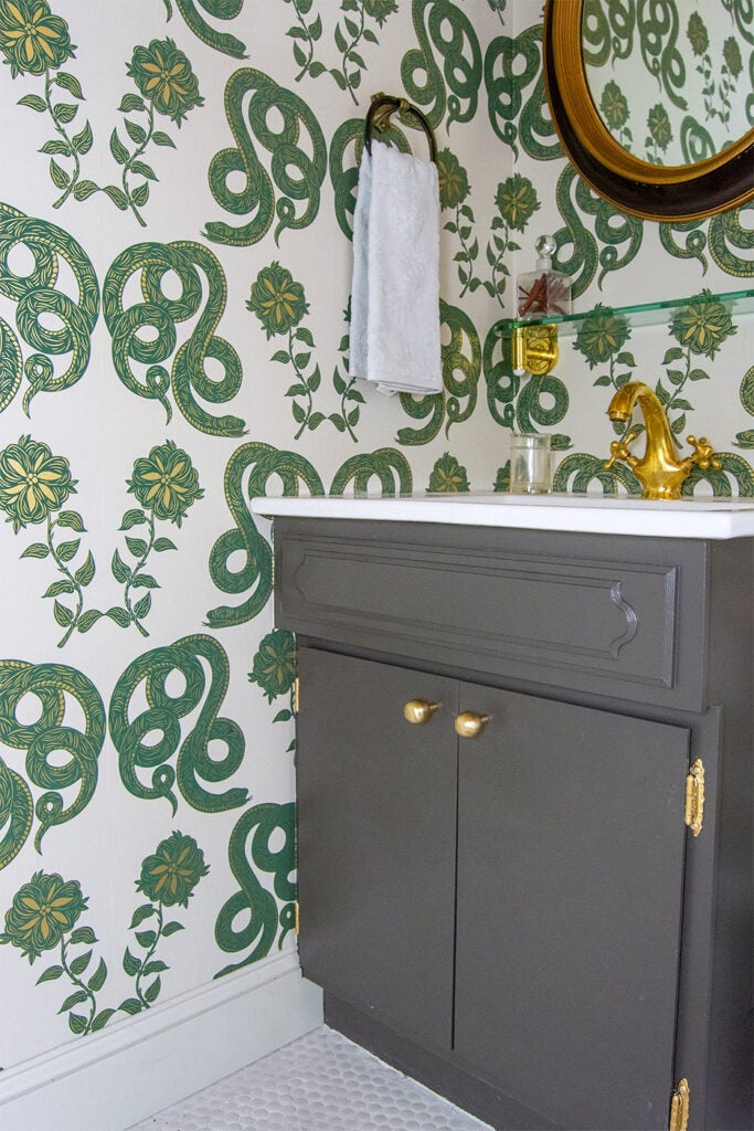gray bathroom vanity with gold hardware green and white wallpaper