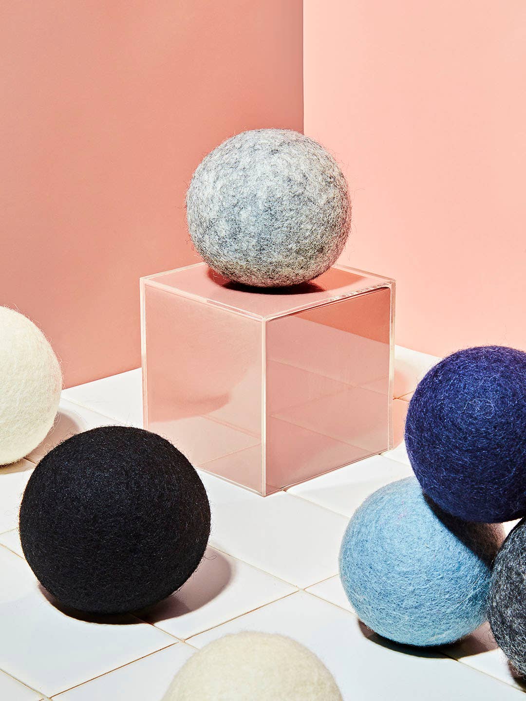 Colorful, wool dryer balls amid pink background