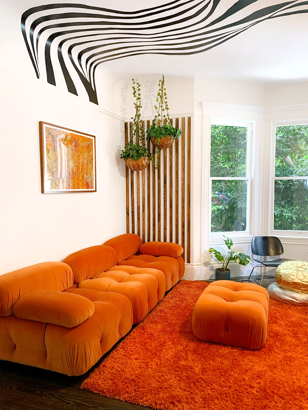 living room with orange sofa and zebra mural