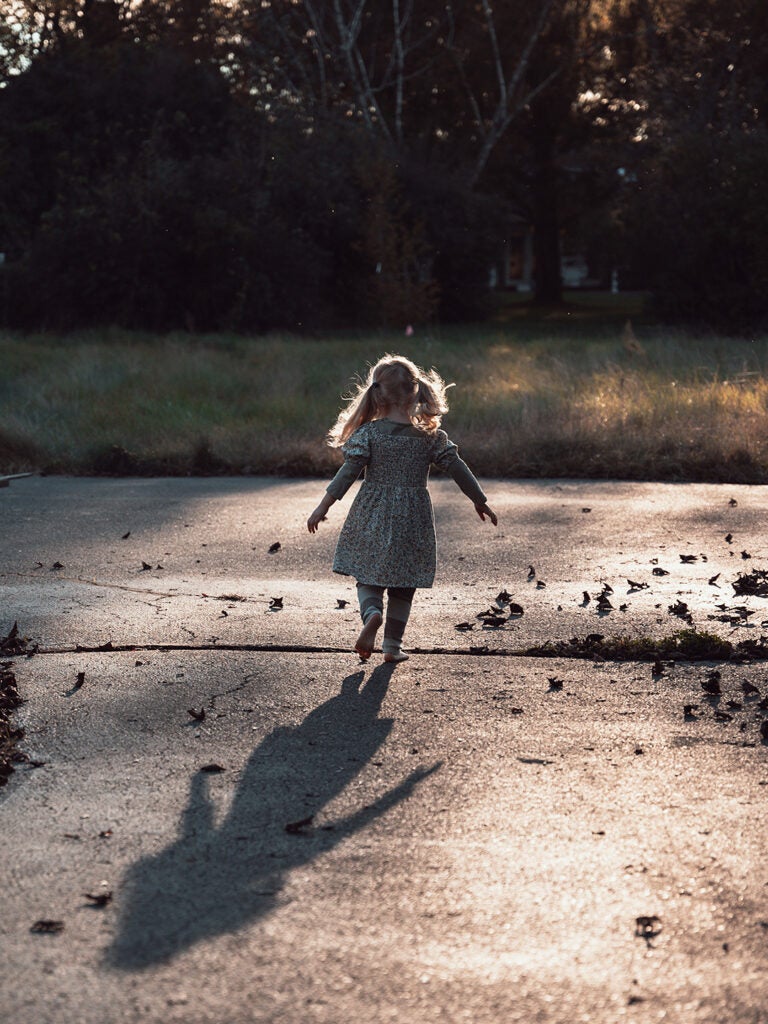 young girl running in driveway