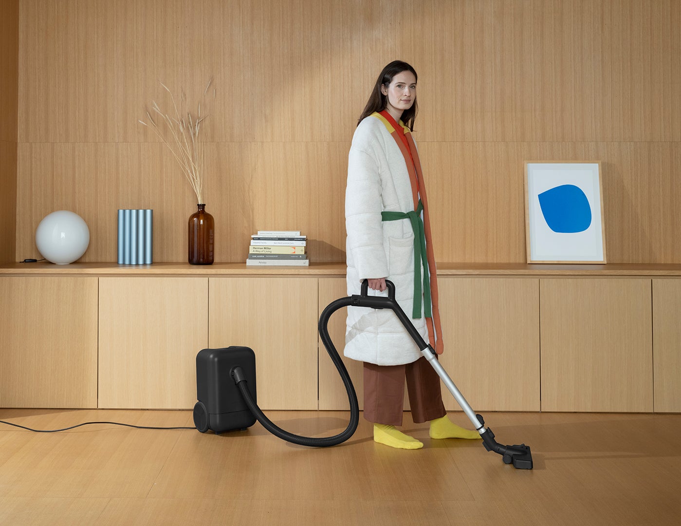 woman holding vacuum wearing housecoat