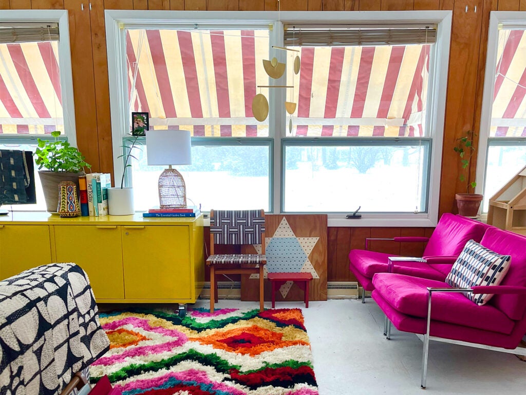 view from colorful 1960s-style living room out windows with striped awning
