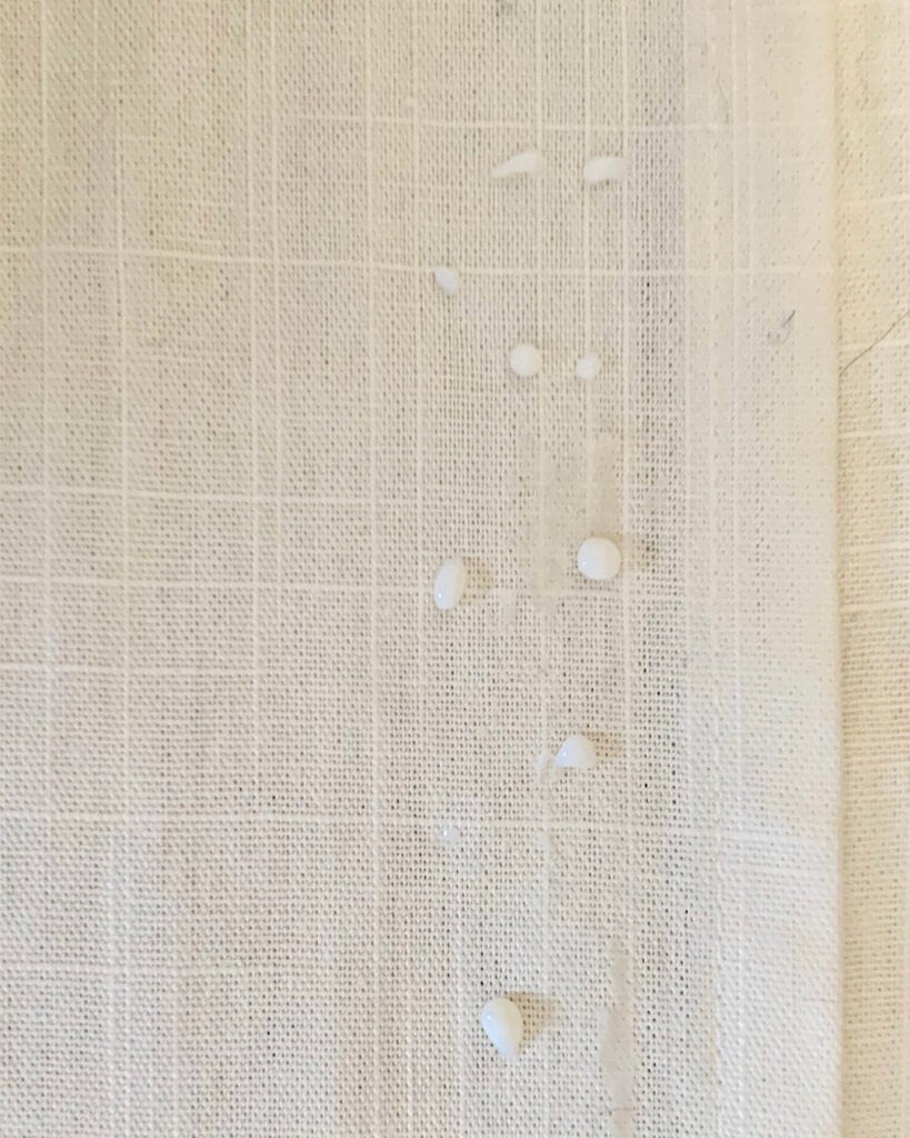fabric glue on edge of white curtain