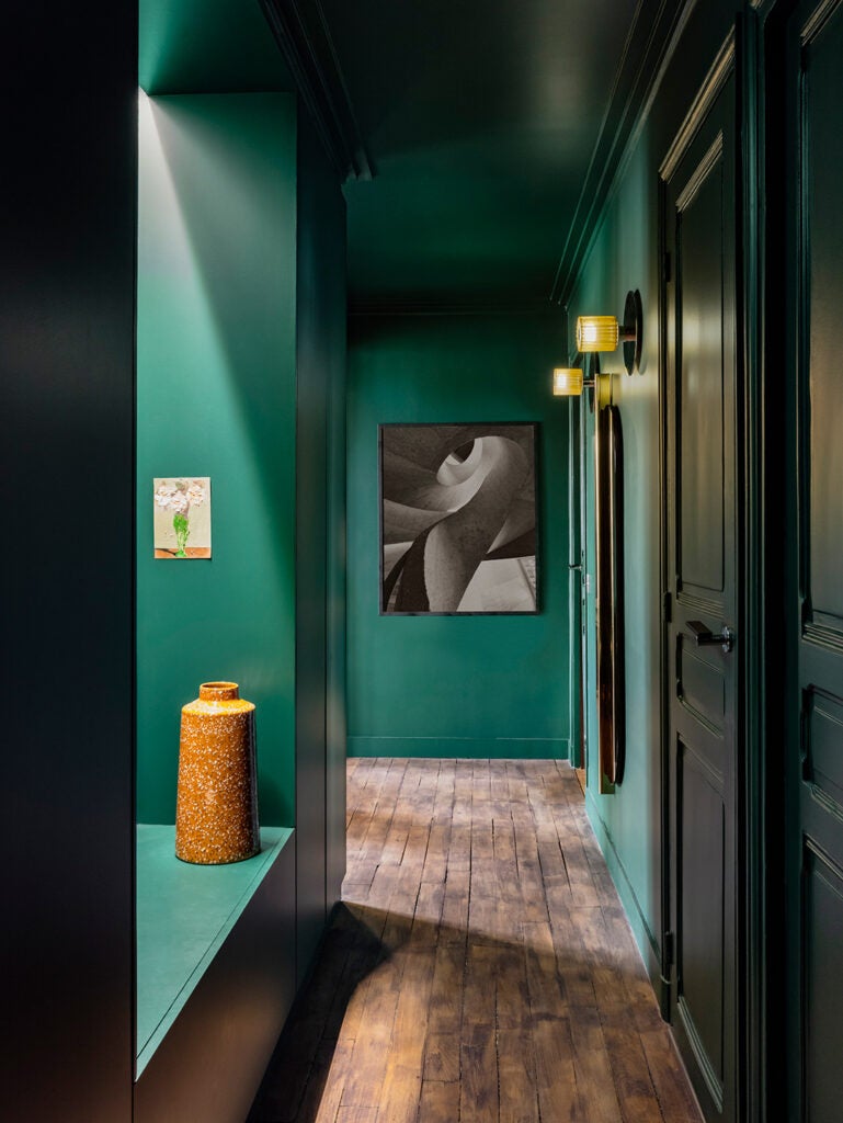 Forest green hallway with grayscale painting.