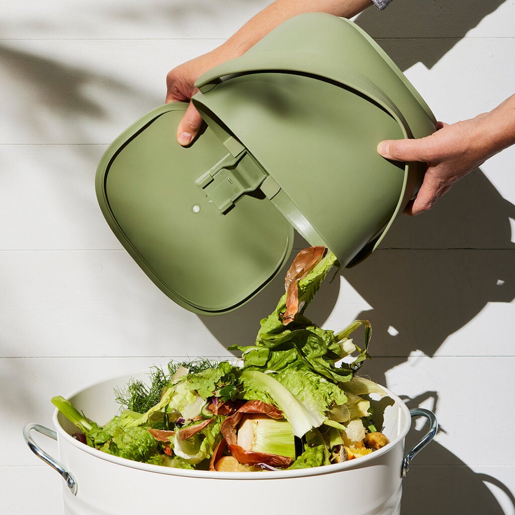 green compost bin dumping out food scraps.
