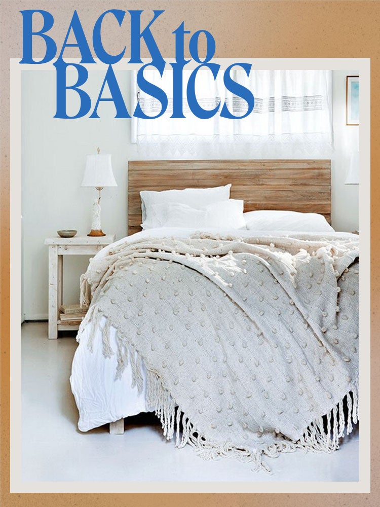bed with white comforter and tan fringed throw