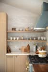 Open shelving in a kitchen with wooden cabinets