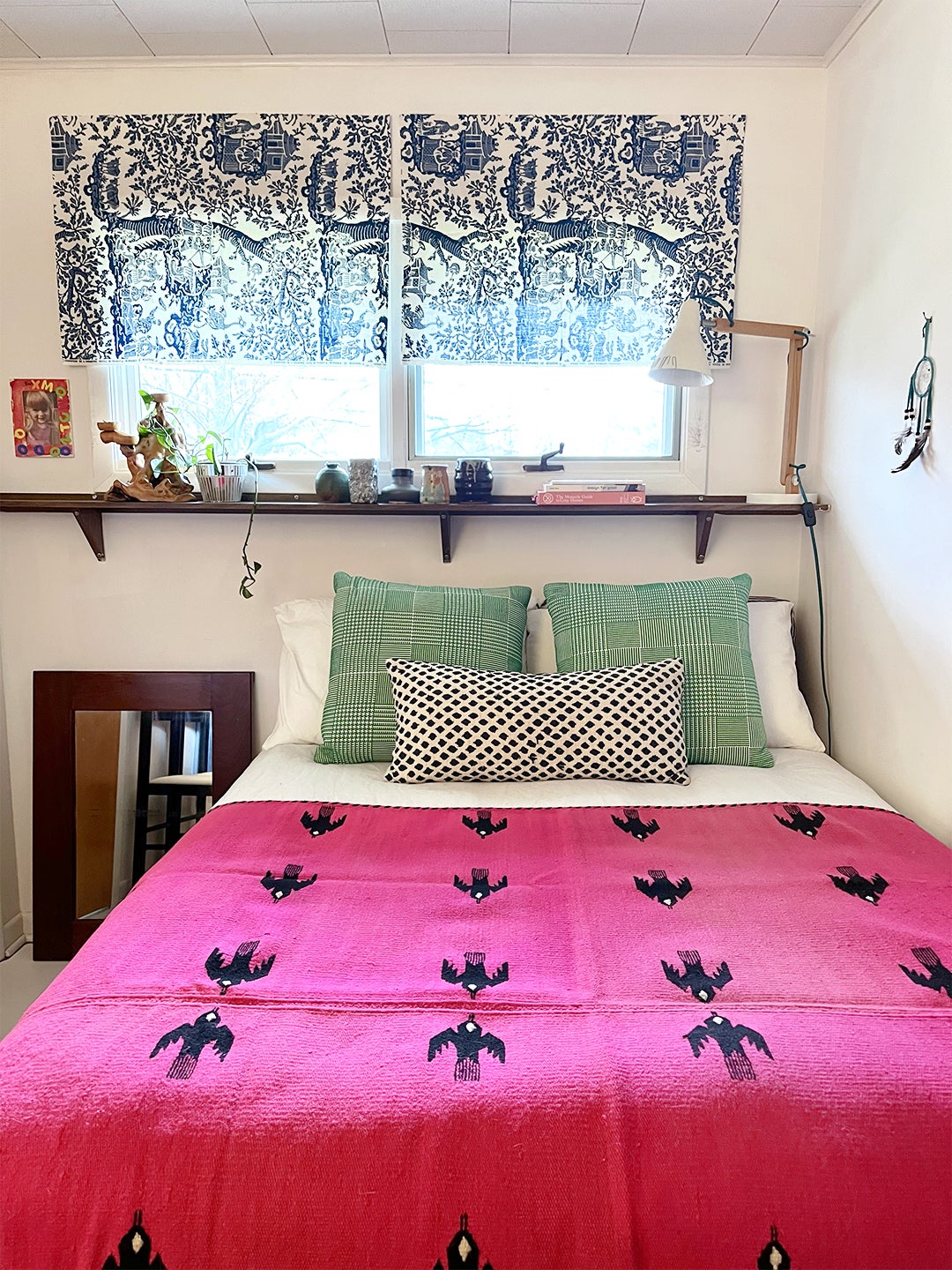 small bedroom with hot pink blanket and mix of patterns