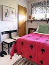 small bedroom with hot pink blanket and mix of patterns