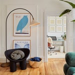 living room with black armchair and arch lamp