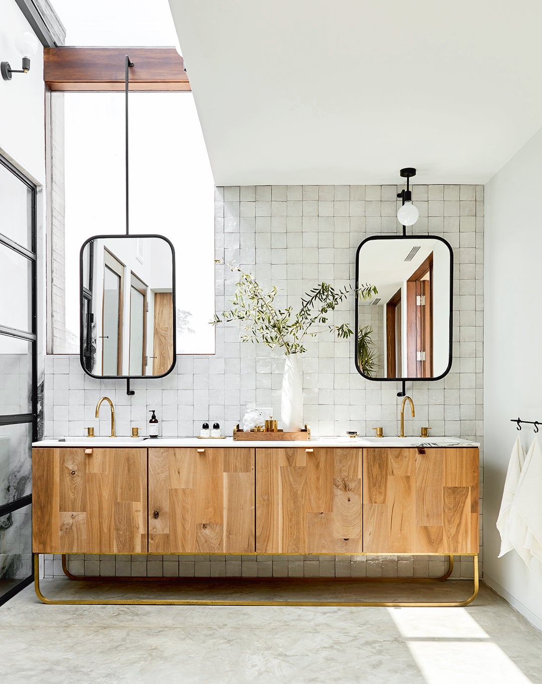 bathroom with wooden vanity and rounded square mirrors