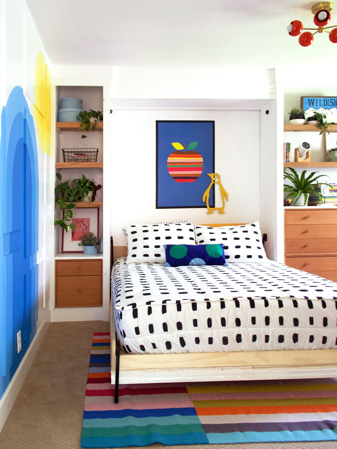 murphy bed next to blue and yellow wall mural