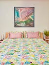 bed with flower-printed comforter and pillows with pink cases