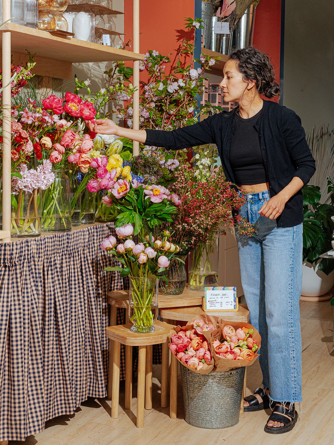 florist arranging flowers on shelf