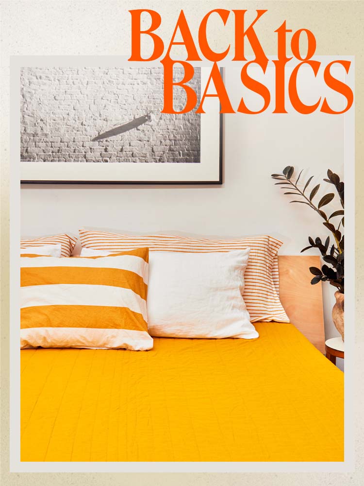 bed with orange duvet cover and white and orange striped pillow
