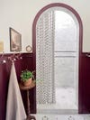 eggplant painted bathroom with arched shower stall.