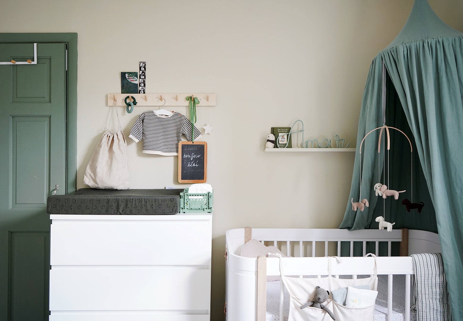 modern white crib and changing table with green accents