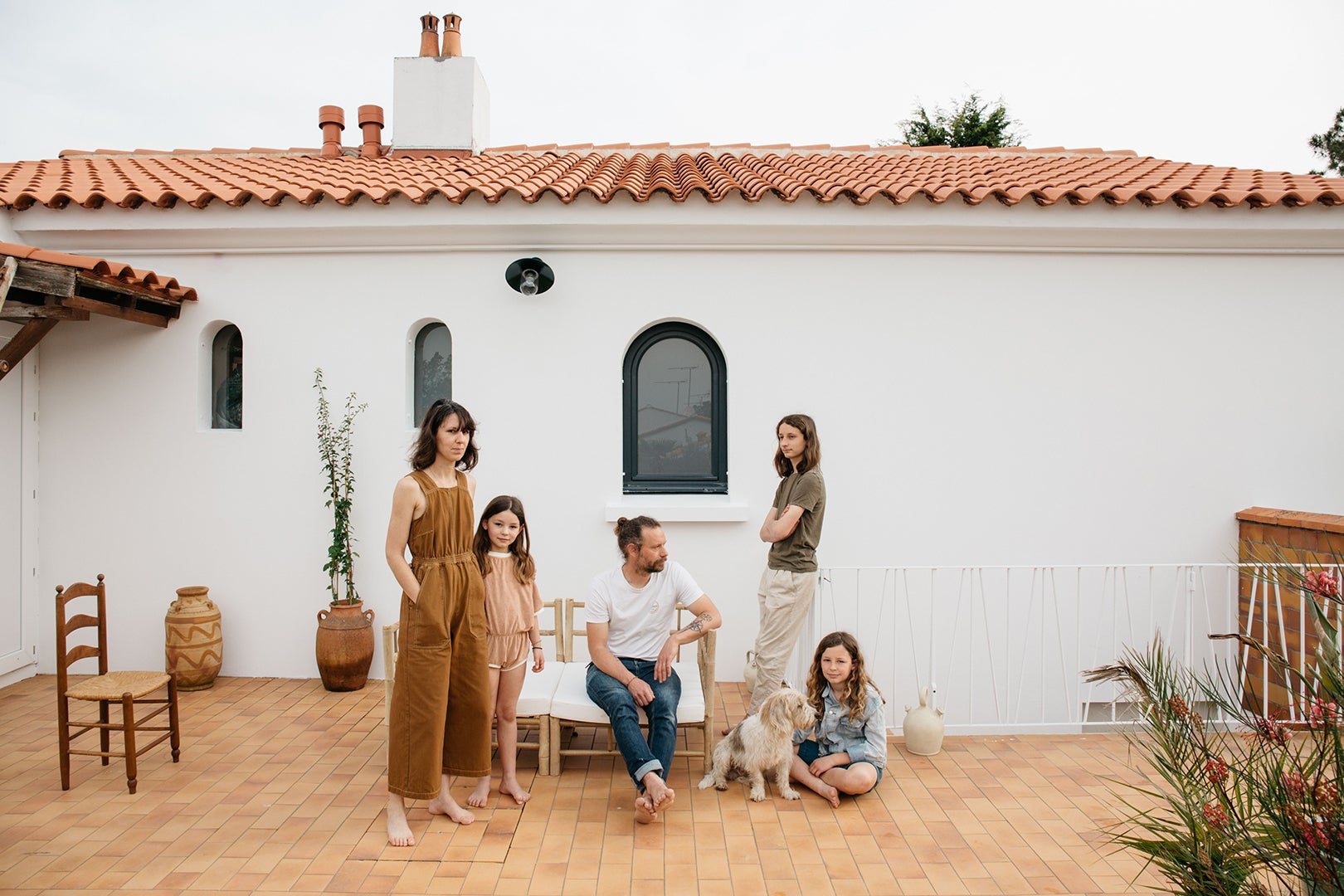Family portrait outside of home with tiled outdoor floor and dog