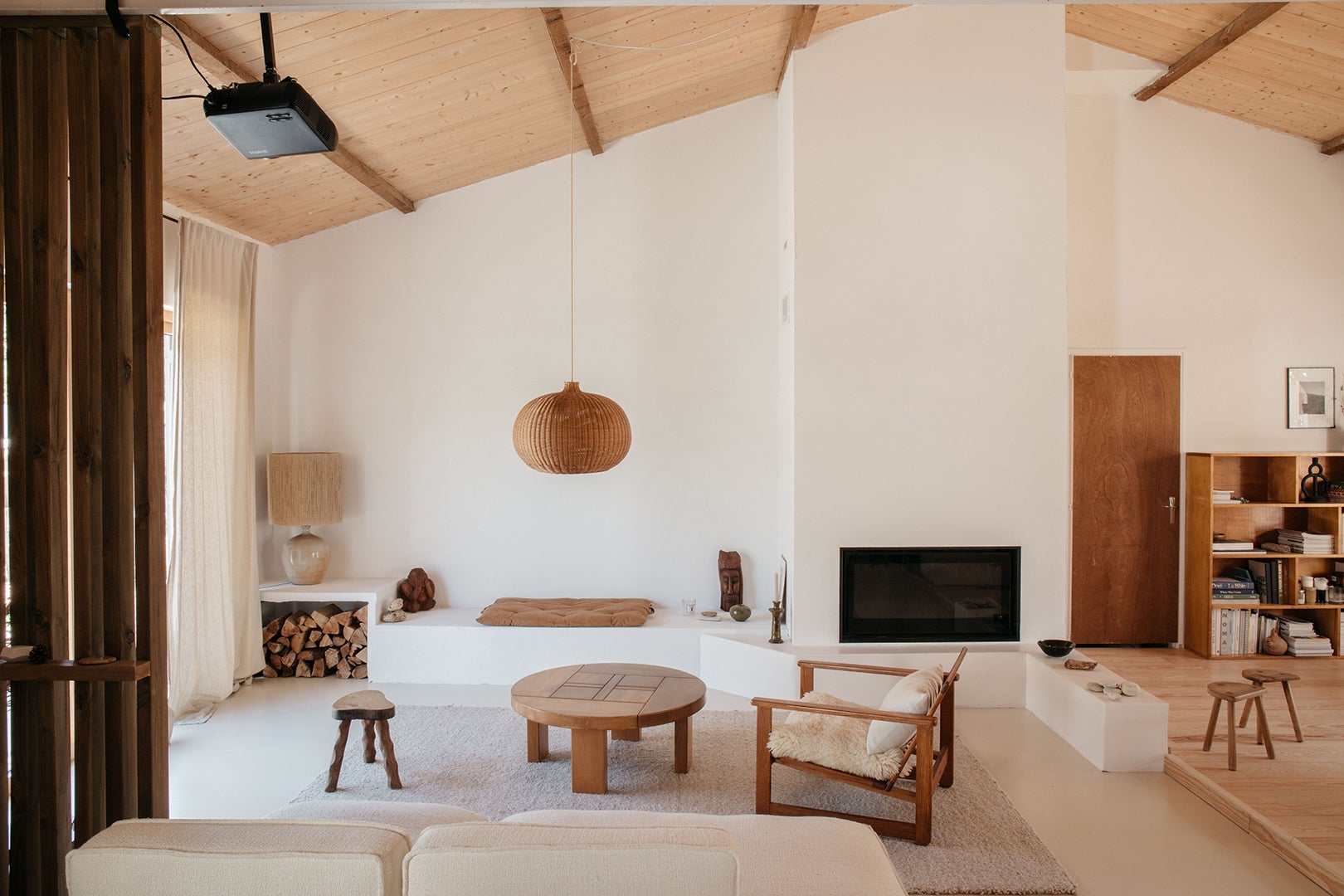 Open living room, white walls, wood ceiling with rattan light fixture