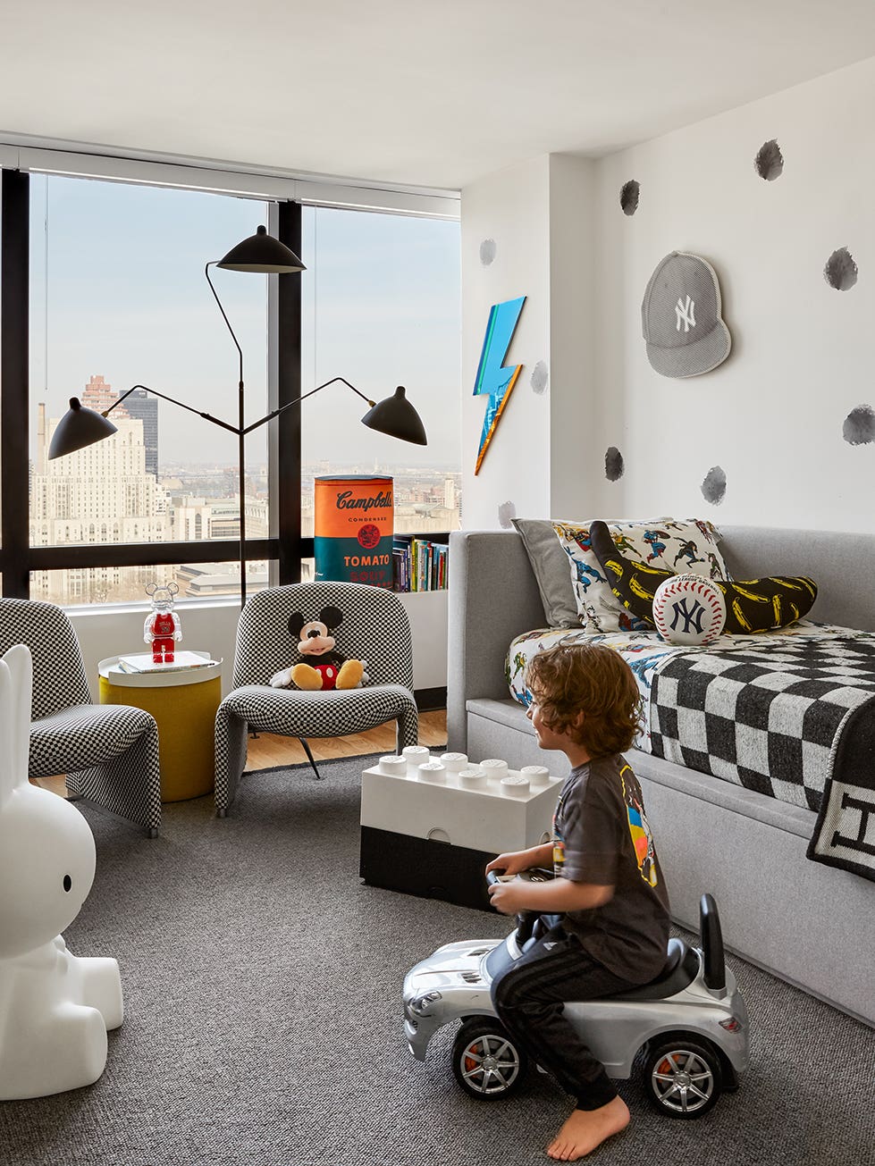 black and white kid’s room with boy on mini car