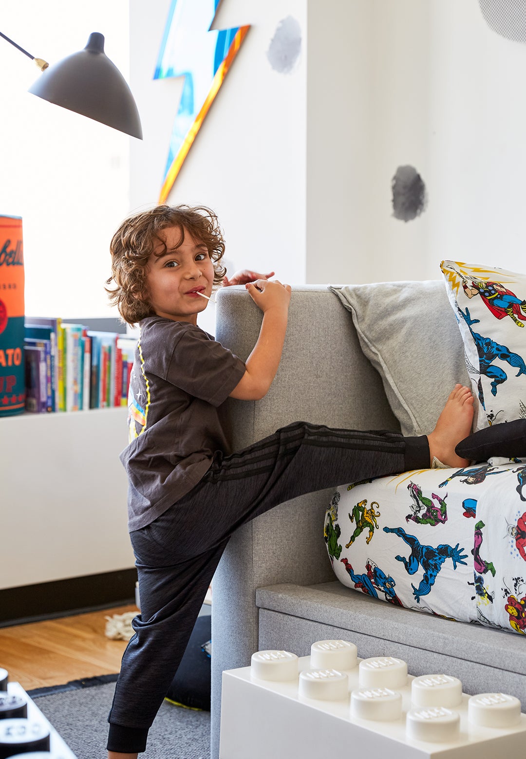 little boy climbing on gray twin bed with storage underneath