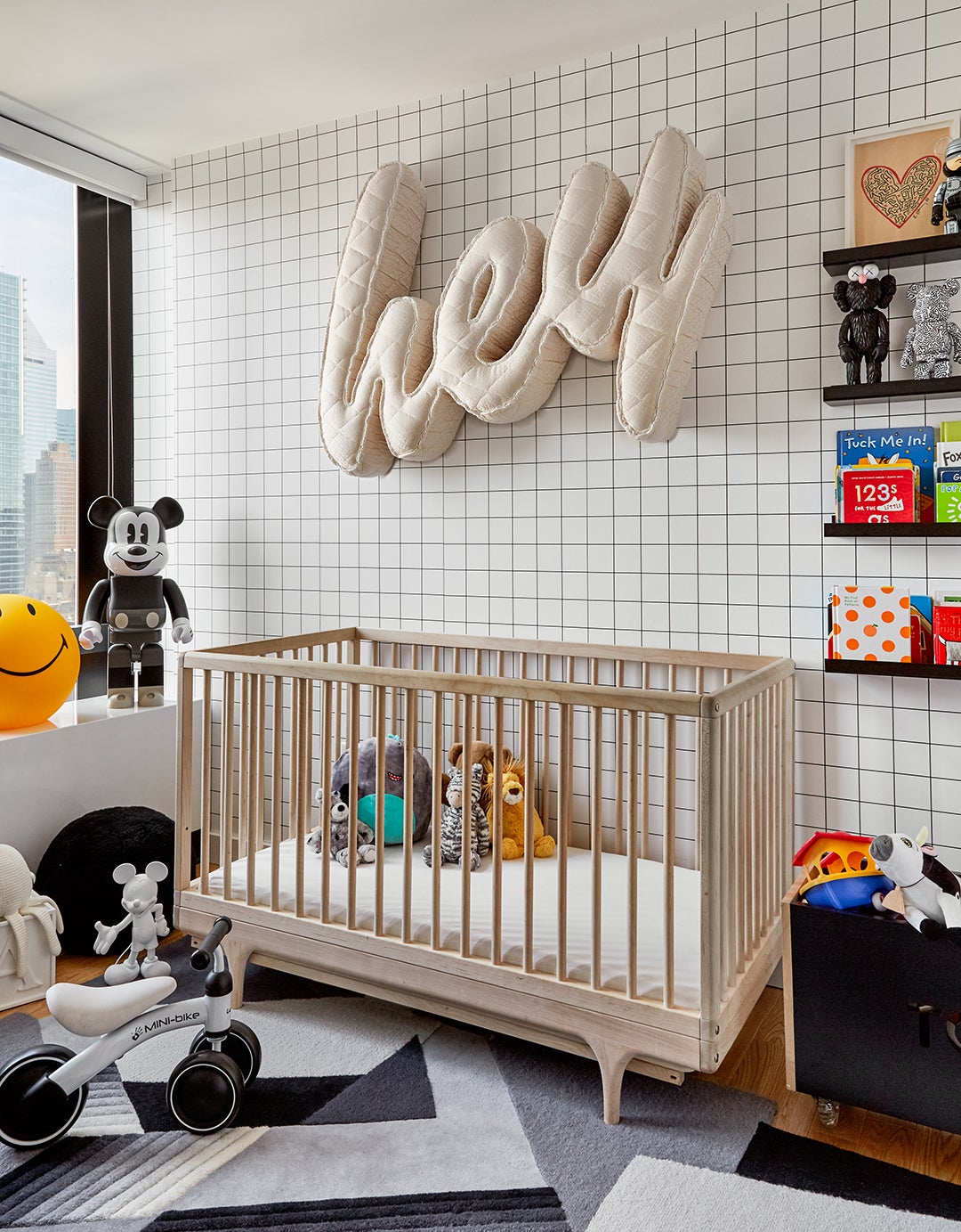 black and white nursery with grid wallpaper and quilted sign