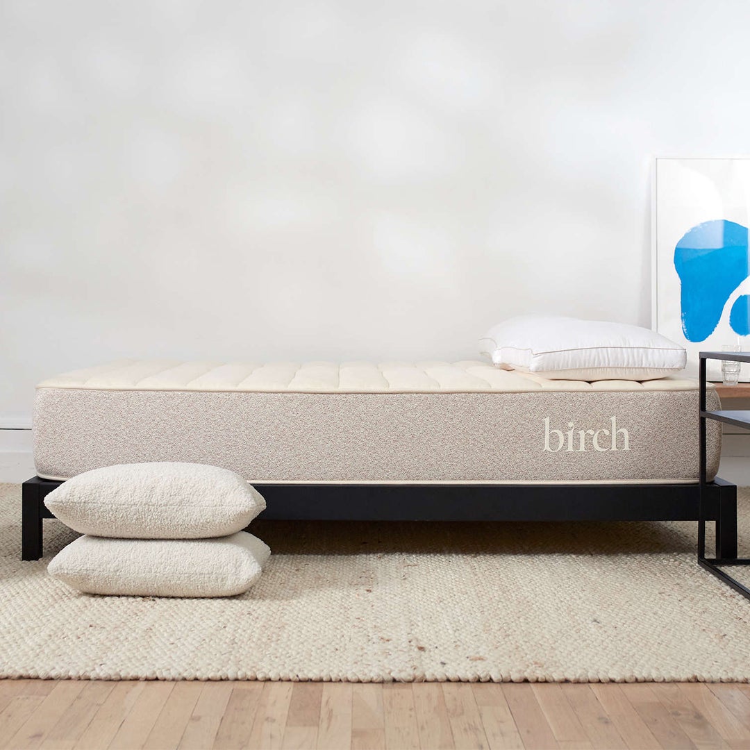 side view of birch mattress with two pillows on the floor