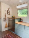 camper kitchen with stainless steel mini fridge
