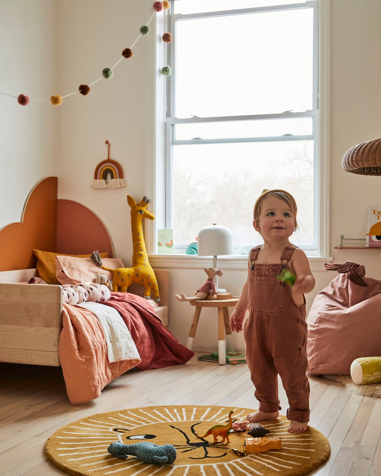 kid’s room with orange arches behind bed and toddler playing