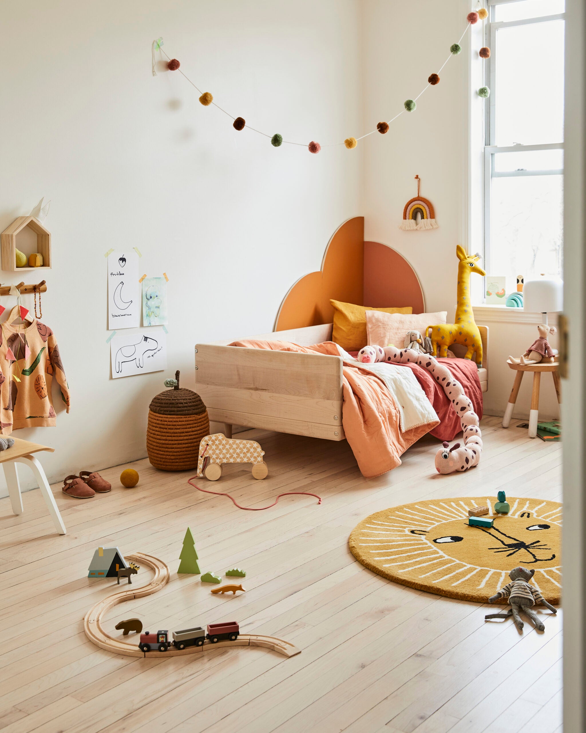 kidâs room with orange arches behind bed and toys on floor