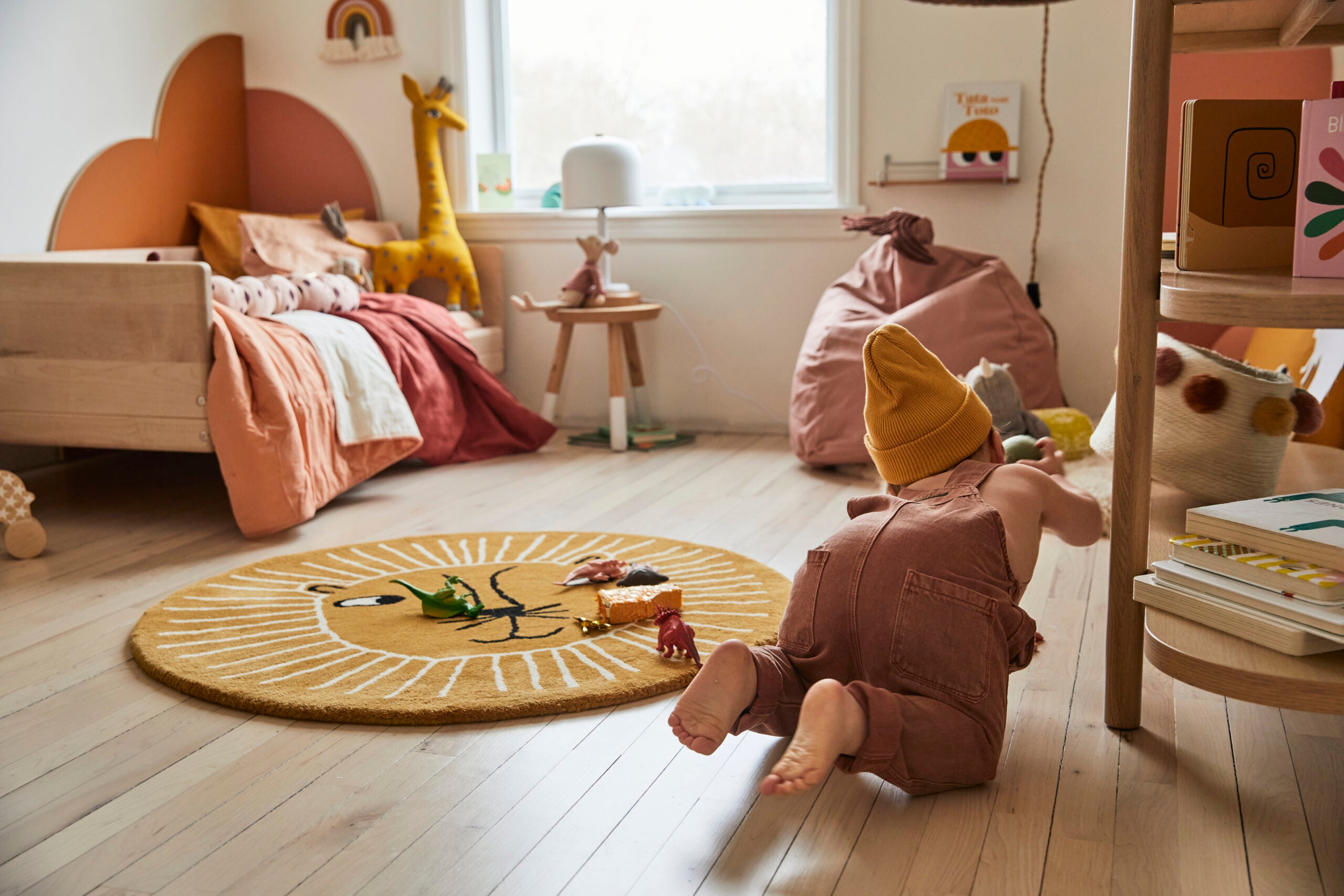 toddler crawling in bedroom with wood bookcase and beanbag