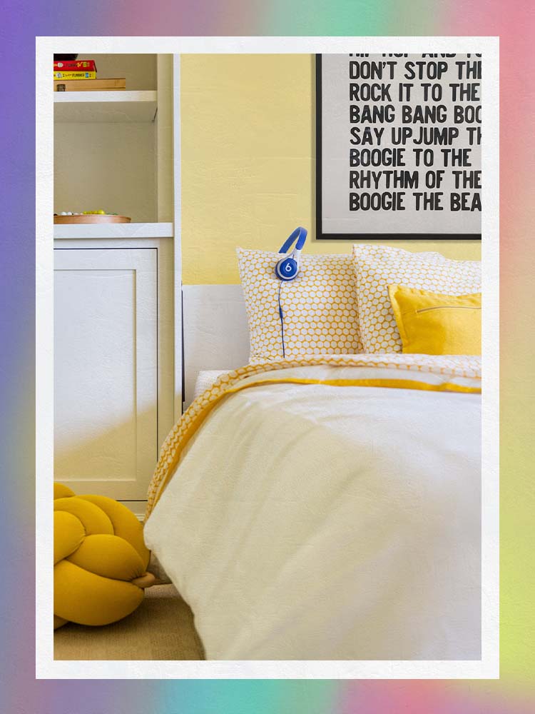 Yellow Kids Bedroom with yellow pillows and art above bed