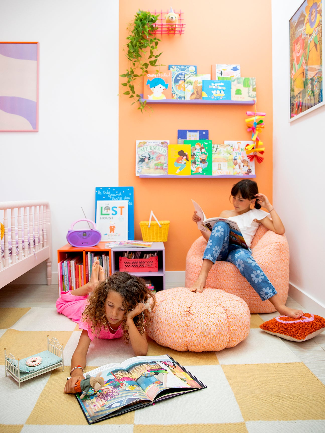 kidsâ reading nook with salmon-colored wall stripe and lavender shelves