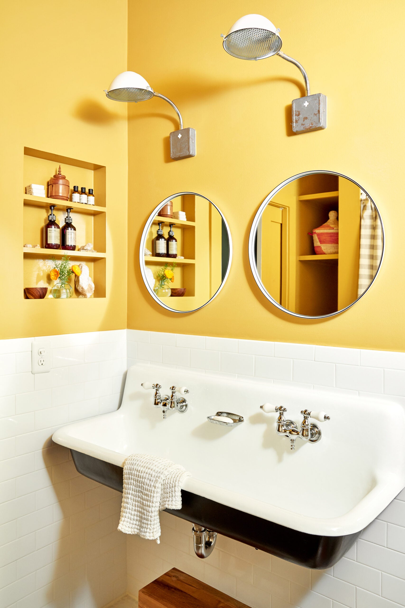 Farmhouse sink in yellow bathroom with white subway tile