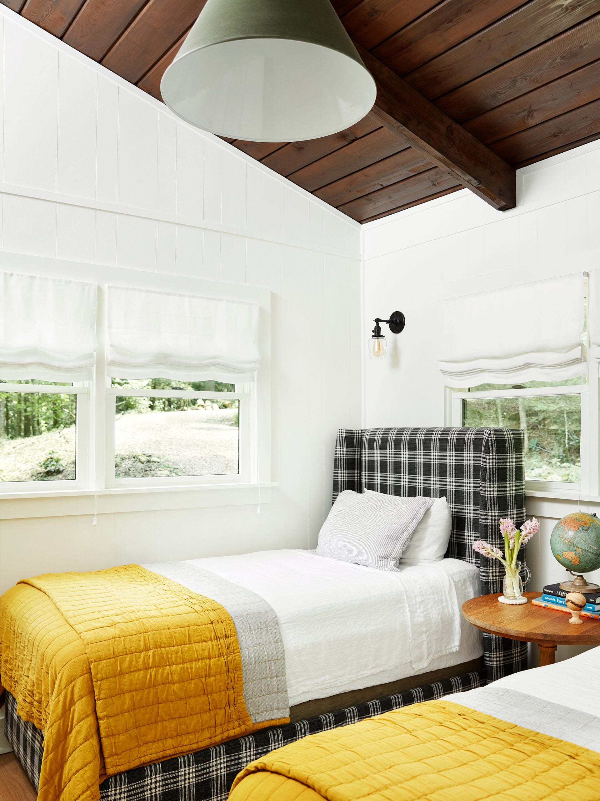 Twin bed with plaid bed frame and wood ceilings