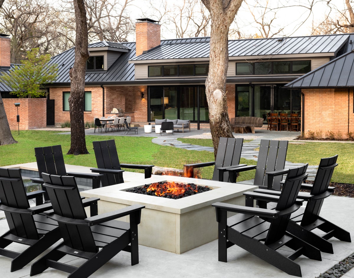 concrete fire pit surrounded by black chairs