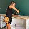 Woman drilling wooden countertop.