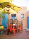 brick patio with red patio furniture and yellow umbrella