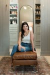 woman sitting on a leather bench in closet