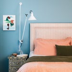 bedding with orange shets and green comforter and throw pillows