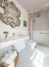 accessible white bathroom with shell mirror