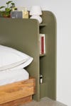 Olive colored headboard with hidden shelves on the side
