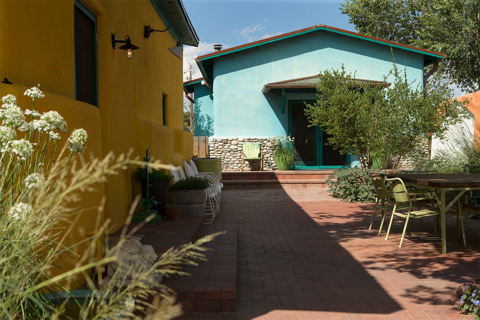 yellow and turquoise home exteriors with brick patio
